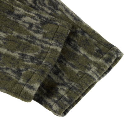 Close-up of the Midweight Hydrowool Softshell Pant’s green-and-black mottled hem, showcasing durable, windproof, waterproof fabric with stretch for outdoor performance.