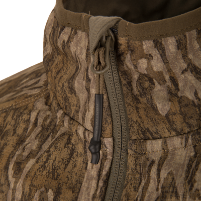 Close-up of the Non-Typical SWT Hybrid Half Zip showcasing its wood-grain camo pattern, zippered front with paracord pull tab, and detailed stitching.