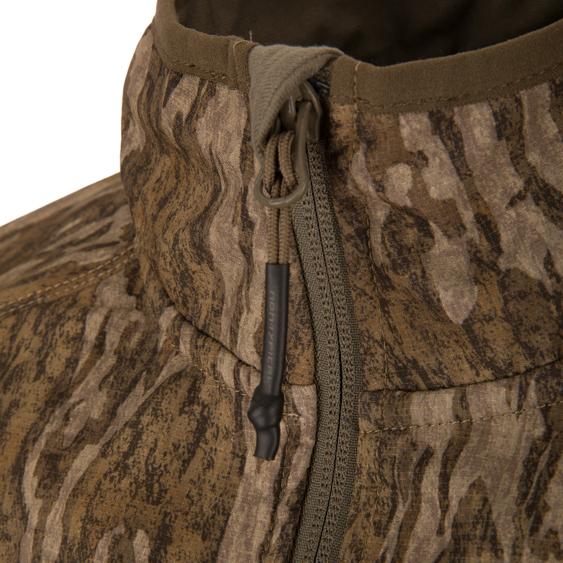 Close-up of the Non-Typical SWT Hybrid Half Zip showcasing its wood-grain camo pattern, zippered front with paracord pull tab, and detailed stitching.