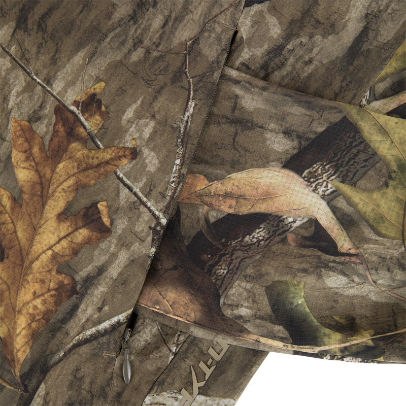 Non-Typical Lightweight SWT Half Zip Pullover with Scent Control featuring a leaf and twig camo pattern, visible zipper pull, and ripstop weave texture.