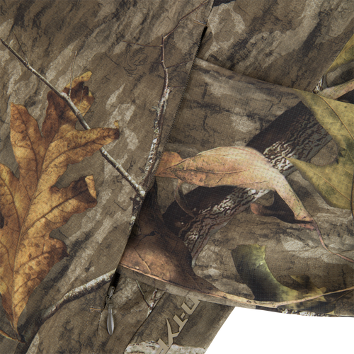 Non-Typical Lightweight SWT Half Zip Pullover with Scent Control featuring a leaf and twig camo pattern, visible zipper pull, and ripstop weave texture.