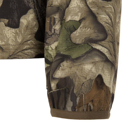 Close-up of the Non-Typical Lightweight SWT Half Zip Pullover, showcasing its woodland camo pattern, durable ripstop weave, and hemmed edge against a plain background.