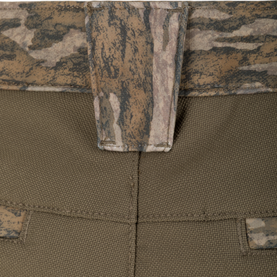 Close-up of olive green Non-Typical Pursuit Softshell Pant with Agion Active X2 tactical softshell pants featuring a camouflage patterned waistband and belt loop.