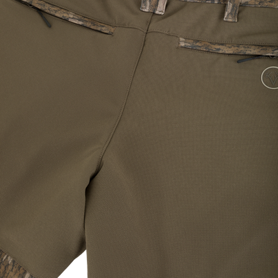 Non-Typical Pursuit Softshell Pant with Agion Active X2 in olive green featuring zippered back pockets and camouflage trim at the waistband and hems.