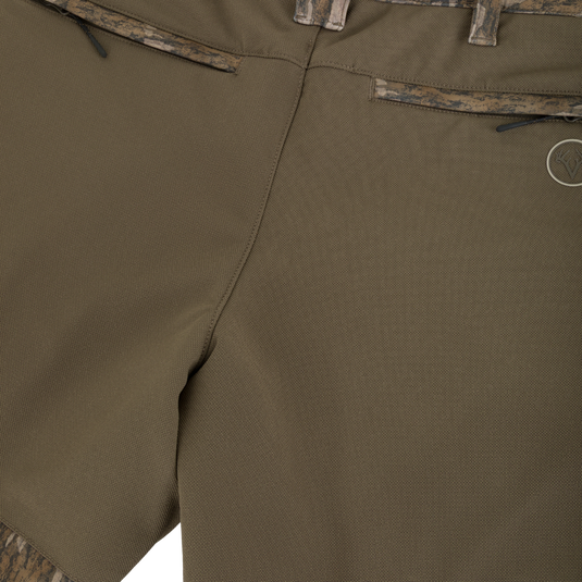 Non-Typical Pursuit Softshell Pant with Agion Active X2 in olive green featuring zippered back pockets and camouflage trim at the waistband and hems.