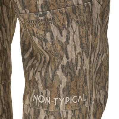 Close-up of Non-Typical Pursuit Softshell Pant with Agion Active X2 windproof water-resistant hunting pants in Mossy Oak Bottomland camouflage, with Non-Typical printed on the thigh.
