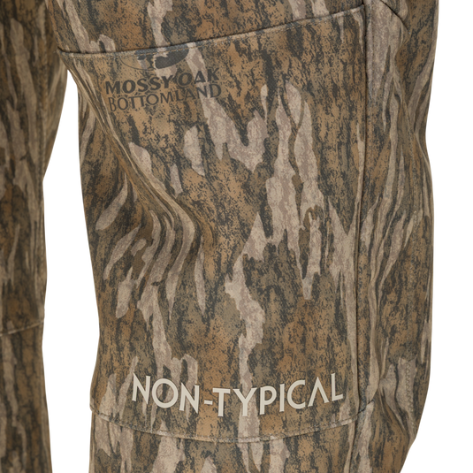 Close-up of Non-Typical Pursuit Softshell Pant with Agion Active X2 windproof water-resistant hunting pants in Mossy Oak Bottomland camouflage, with Non-Typical printed on the thigh.