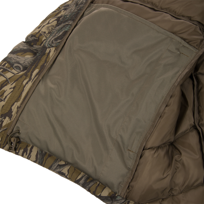Close-up of the Non-Typical Down Jacket with Agion Active X2 by Nontypical, featuring a large inner left pocket and visible quilted lining inside its camouflage-patterned insulated design.