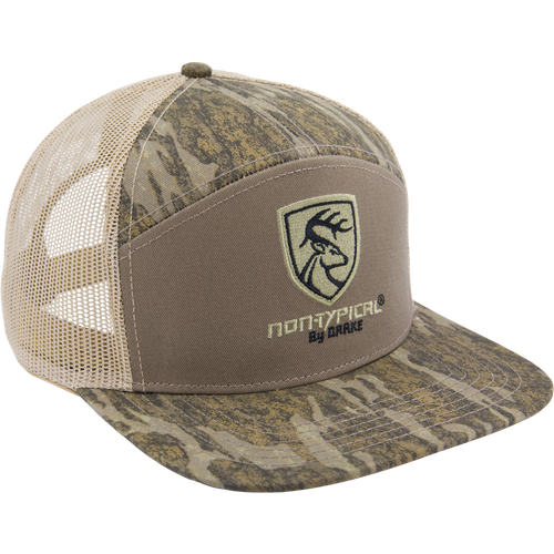 Camo-patterned trucker cap with flat brim, mesh back, and embroidered deer-head shield logo, labeled Non-Typical X Lost Sa7age 7 Panel Cap by Drake.