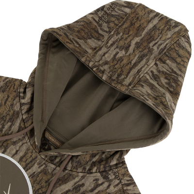 Non-Typical Performance Hoodie with Scent Control features Mossy Oak Bottomland camo, inner-lined hood, drawcord, and kangaroo pocket, perfect for durable and stylish outdoor activities.