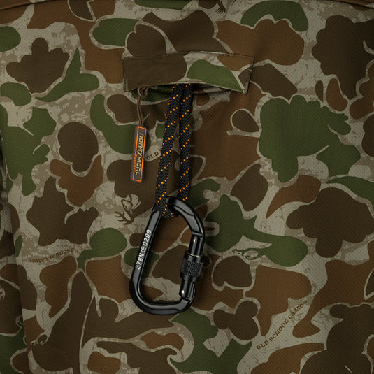 A close-up of the Youth Silencer Full Zip Jacket, featuring a black carabiner and a camo pattern. Perfect for hunters seeking warmth, breathability, and scent control.