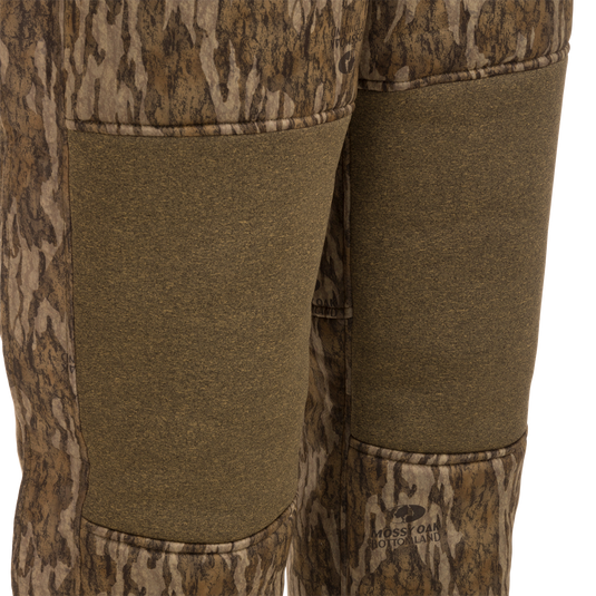 Close-up of Silencer Bib pants showcasing soft, durable fabric and vertical chest pockets with lanyards for hunting gear.