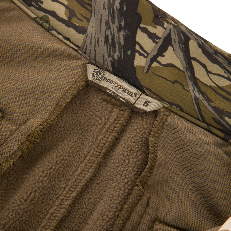 Close-up of the Non-Typical Endurance Pant with Scent Control, featuring soft brown fleece lining, camo trim, and Northfinder label, size S, for versatile hunting comfort.