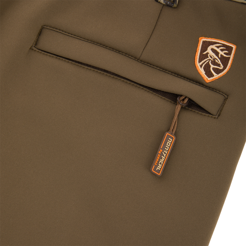 Close-up of Non-Typical Endurance Pant with Scent Control, featuring a zippered pocket with Nontypical pull-tab and an embroidered deer head patch above the pocket.