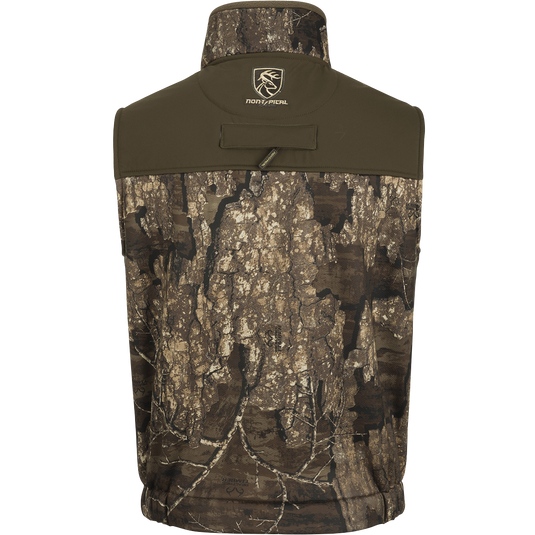 A close-up of the Standstill Windproof Vest with Agion Active XL®. Perfect for mid-to-late season hunting, this versatile vest features a tree pattern, logo of a deer, and camouflaged surface. Made with durable fabric and equipped with scent control technology, zippered pockets, and a safety harness pass-through opening. Ideal for layering or wearing over a mid-layer.