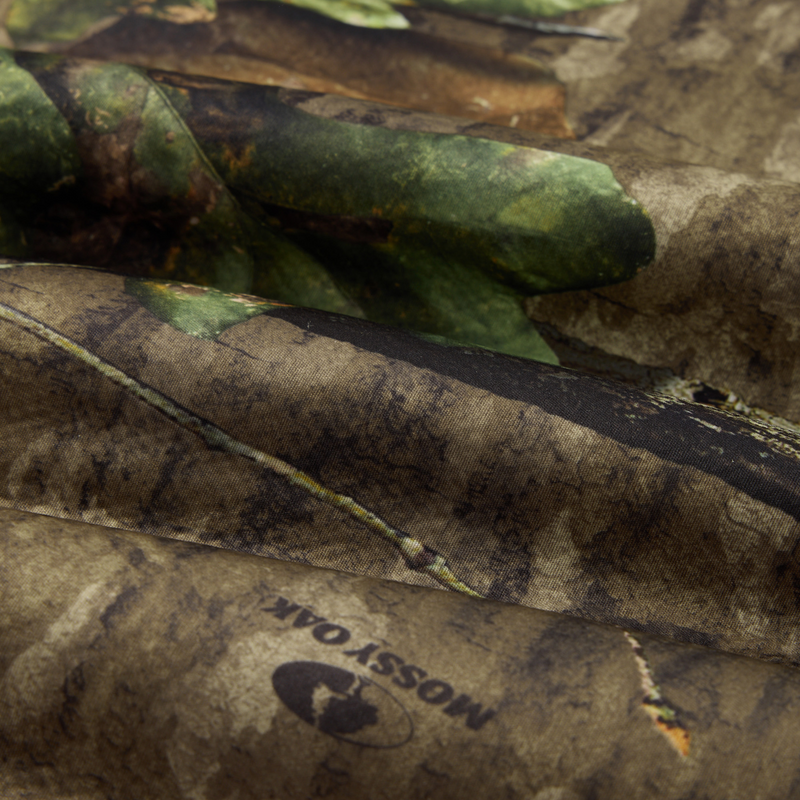 Close-up of folded Non-Typical Silencer Hoodie with Agion Active X2, showcasing Mossy Oak camouflage pattern, highlighting its breathable polyester and high-pile sherpa fleece composition.