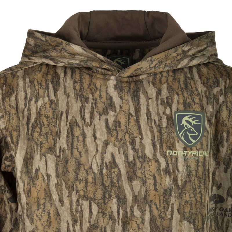 A youth performance hoodie with a camouflage pattern and logo, featuring a double-lined hood and kangaroo pouch for extra warmth and comfort. Made with soft, combed fleece interior and excellent stretch. Perfect for everyday use and outdoor activities.
