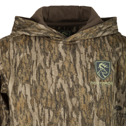 A youth performance hoodie with a camouflage pattern and logo, featuring a double-lined hood and kangaroo pouch for extra warmth and comfort. Made with soft, combed fleece interior and excellent stretch. Perfect for everyday use and outdoor activities.