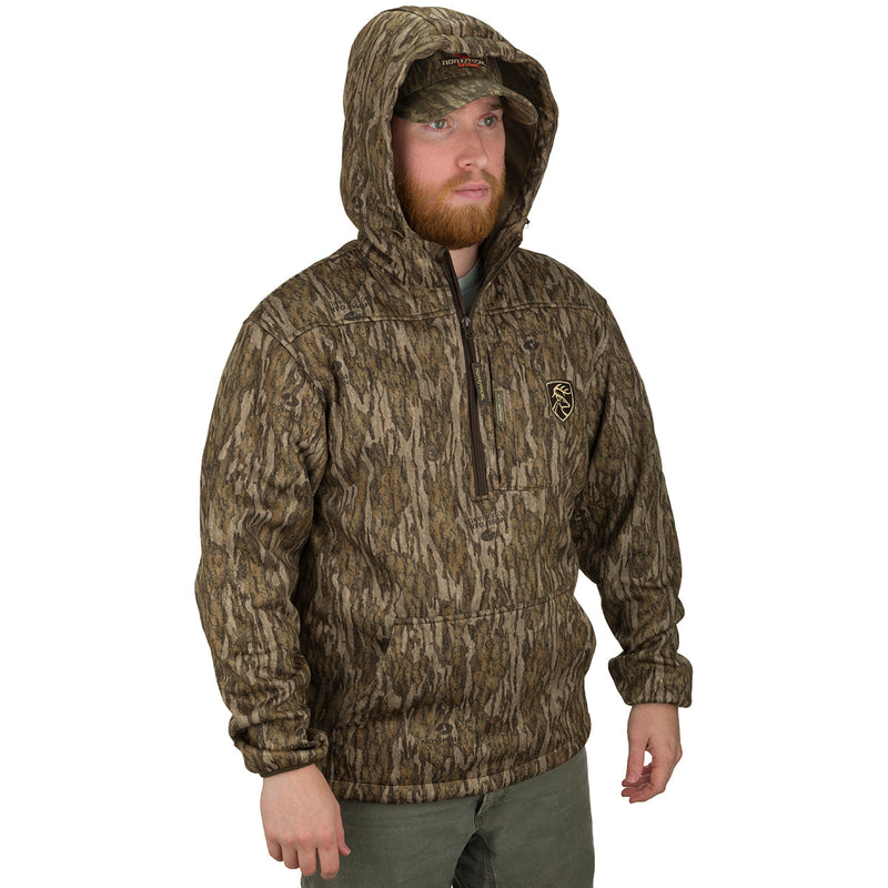 A man wearing the Endurance 1/4 Zip Jacket, a camouflage outerwear with a deep quarter-zip neck and a vertical magnetic chest pocket. The lightweight soft-shell fabric stretches for ease of movement while hunting. Features Agion Active XL® scent control technology for odor control.