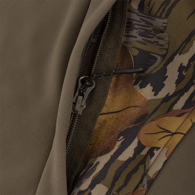 Close-up of the zipper on a Non-Typical Endurance Hooded Full Zip Jacket with Scent Control, featuring a solid olive-green panel on one side and a leaf camouflage pattern on the other.