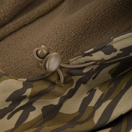 Youth Endurance Full Zip Jacket with Hood featuring camo pattern, brown fleece lining, elastic draw-cord hem, and plastic toggle for adjustable fit.