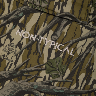 Close-up of a Youth Endurance Full Zip Jacket with Hood in a tree-bark camouflage pattern, featuring the embroidered text Nontypical and a Mossy Oak Treestand logo.