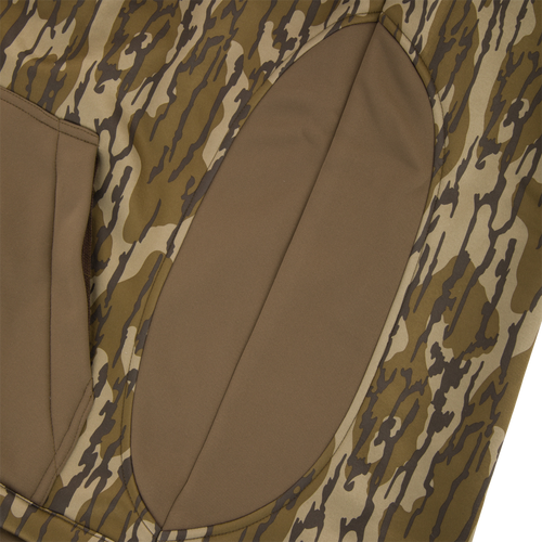 Youth Endurance Full Zip Jacket with Hood featuring woodland camouflage print and brown padded panel, designed for flexibility and warmth with scent control and practical zippered pockets.