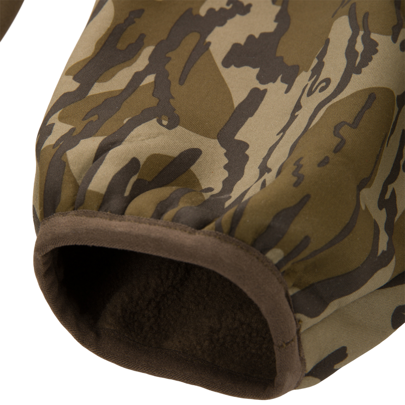 Close-up of the Youth Endurance Full Zip Jacket with Hood sleeve, showcasing its camouflage-print, elasticated cuff, and fleece-lined interior for warmth and flexibility.
