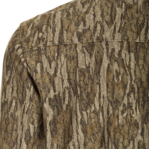A close-up of the MST Microfleece Softshell Shirt - Realtree, a camouflage shirt made of wind-resistant brushed softshell fabric and lined with microfleece. Features include scent control technology, a 7-button placket, gusseted underarm, and 4-way stretch. Two pockets provide added convenience.