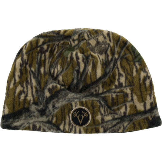 Non-Typical Windproof Fleece Beanie with Agion Active X2 in a dark forest camouflage pattern, featuring a circular patch with a deer antler logo on the front for added ear coverage.