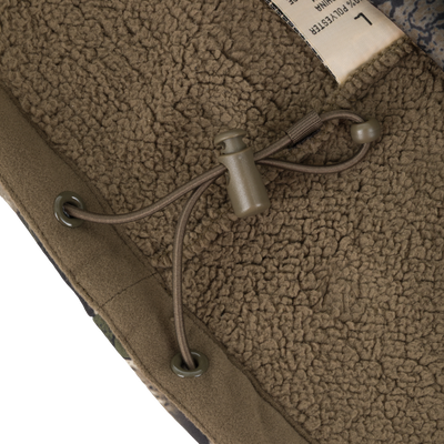 Close-up of the brown Non-Typical Slacker Quarter Zip Hoodie by Nontypical, featuring an adjustable drawstring with toggle and metal eyelets on a textured lining. A partially visible white label appears in the top right corner.