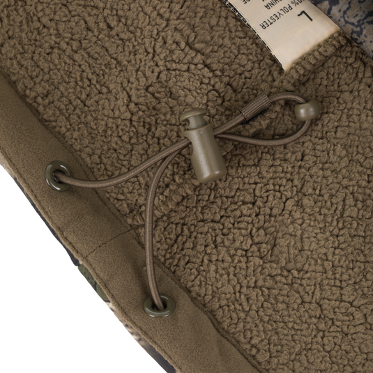Close-up of the brown Non-Typical Slacker Quarter Zip Hoodie by Nontypical, featuring an adjustable drawstring with toggle and metal eyelets on a textured lining. A partially visible white label appears in the top right corner.