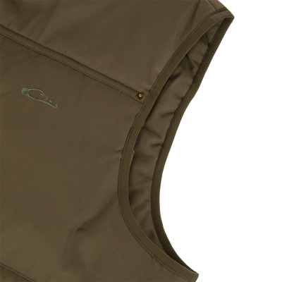 Close-up of the Delta Featherless Down Vest's quilted design, featuring stitched seam pockets with brass snap, embroidered “C” logo, showcasing its lightweight, insulated performance for outdoor wear.