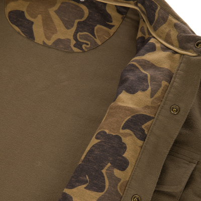 Delta Moleskin Shirt Jacket, olive-green with camo-print lining, features a textured moleskin shell, brass snap buttons, and zipper tape, reflecting rugged outdoor performance.