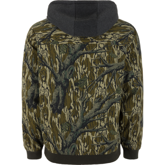 Back view of the Campfire Canvas Bomber Jacket by Lifestyle, featuring a green and brown camo pattern with tree branches and leaves, plus dark ribbed cuffs and hem.