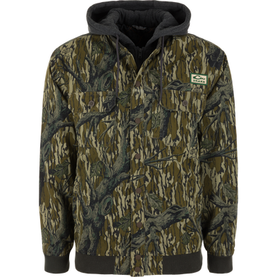The Lifestyle Campfire Canvas Bomber Jacket in Mossy Oak Original Treestand features two chest pockets, a front zipper, and a green logo patch on the left chest.