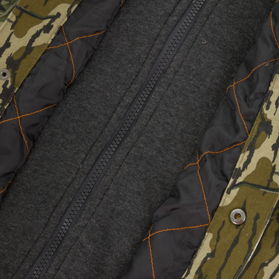 Close-up of the Campfire Canvas Bomber Jacket by Lifestyle, featuring camouflage outer fabric, orange-stitched black quilted lining, and a dark central zipper.