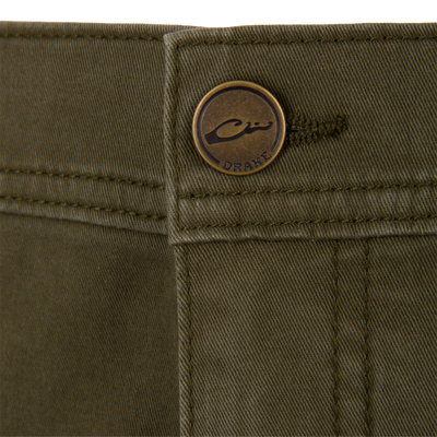 Close-up of olive green Wingshooter Twill 5 Pocket Pants featuring a brass-toned button embossed with a logo.
