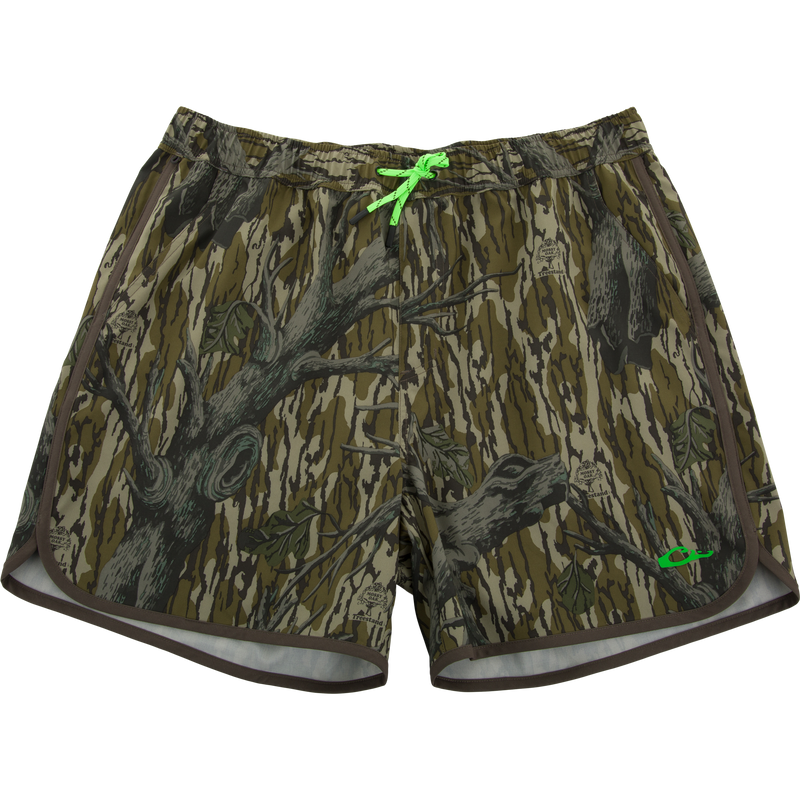 Lake Shore Shorty Short with Mossy Oak camo print, elastic waistband, bright green drawcord, side pockets, and contrasting hem trim, ideal for water activities.