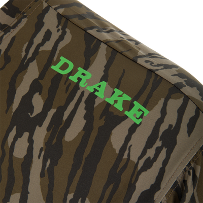 Close-up of the Lake Shore Performance Long Sleeve Crew camo-patterned fabric with “DRAKE” in green, highlighting its cooling, moisture-wicking, and sun-protection features.