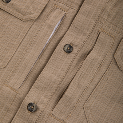 Close-up of Wingshooter Cross Hatch Shirt, highlighting khaki fabric, top-stitched seams, pocket flaps, and button, designed for comfort and performance in outdoor activities.