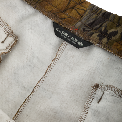 Inside view of camouflage Three End Cargo Sweat Pant showing the fleece lining, seams, and a size large neck label that reads Drake and Made in Bangladesh.