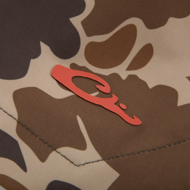 Close-up of the Lake Shore Dock Short's desert-camo fabric with a red emblem, showcasing its durable stitching and lightweight, water-repellent design for outdoor comfort.