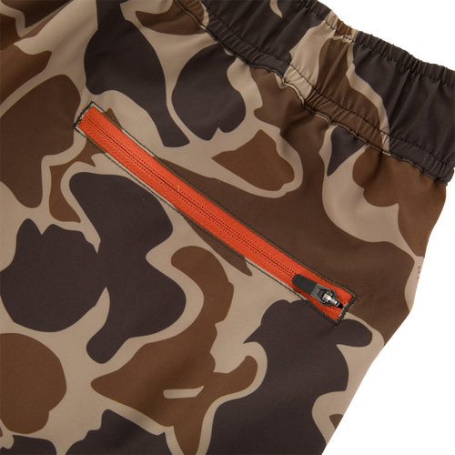 Close-up of Lake Shore Dock Short's camo fabric with an orange zipper, highlighting the durable, water-repellent design and functional pocket for outdoor activities.