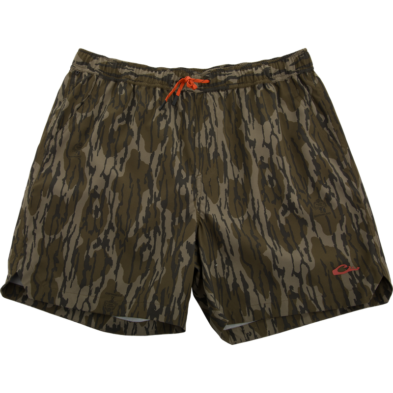 Lake Shore Dock Short with twig camouflage print, bright orange drawcord, and logo. Features elastic waistband, mesh-lined pockets, and zippered side pocket for outdoor activities.