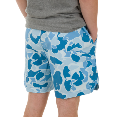 Close-up of a person wearing Lake Shore Dock Short, featuring a light-blue camo pattern, elastic waistband, and mesh-lined pockets, capturing the essence of water-ready comfort.