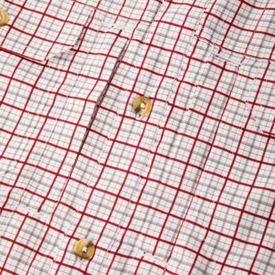 Wingshooter Trey Shirt's close-up showing red-and-gray plaid fabric, tan plastic button, and stitching, highlighting its lightweight, breathable design for hunting and outdoor activities.