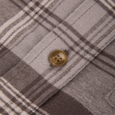 Close-up of Drake Autumn Flannel Shirt's woolly, plaid fabric with a plastic button, showcasing texture and detail, ideal for outdoor autumn activities.