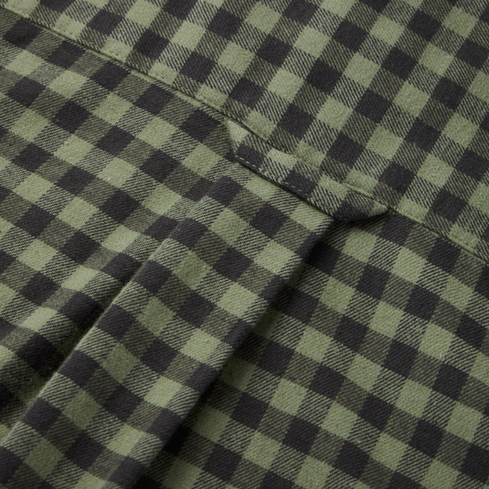 Close-up of the Autumn Flannel Shirt's green and black checkered fabric, showcasing the seam and flap of its patch pocket, emphasizing its outdoor lifestyle design.