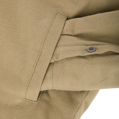Close-up of The Youth Campfire Flannel Hoodie's khaki woven fabric, showing a sewn-in tab and button, highlighting its durable cotton-blend construction for outdoor comfort.